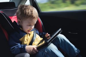 Kind mit Tablet im Auto