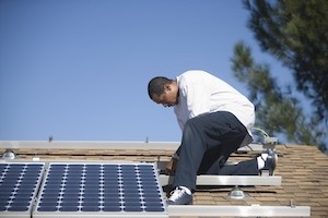 Mann arbeitet an Photovoltaikanlage